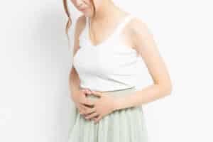A woman holding her stomach in pain from uterine fibroids