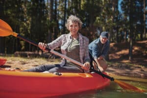 Mature woman smiles while kayaking with her more active lifestyle
