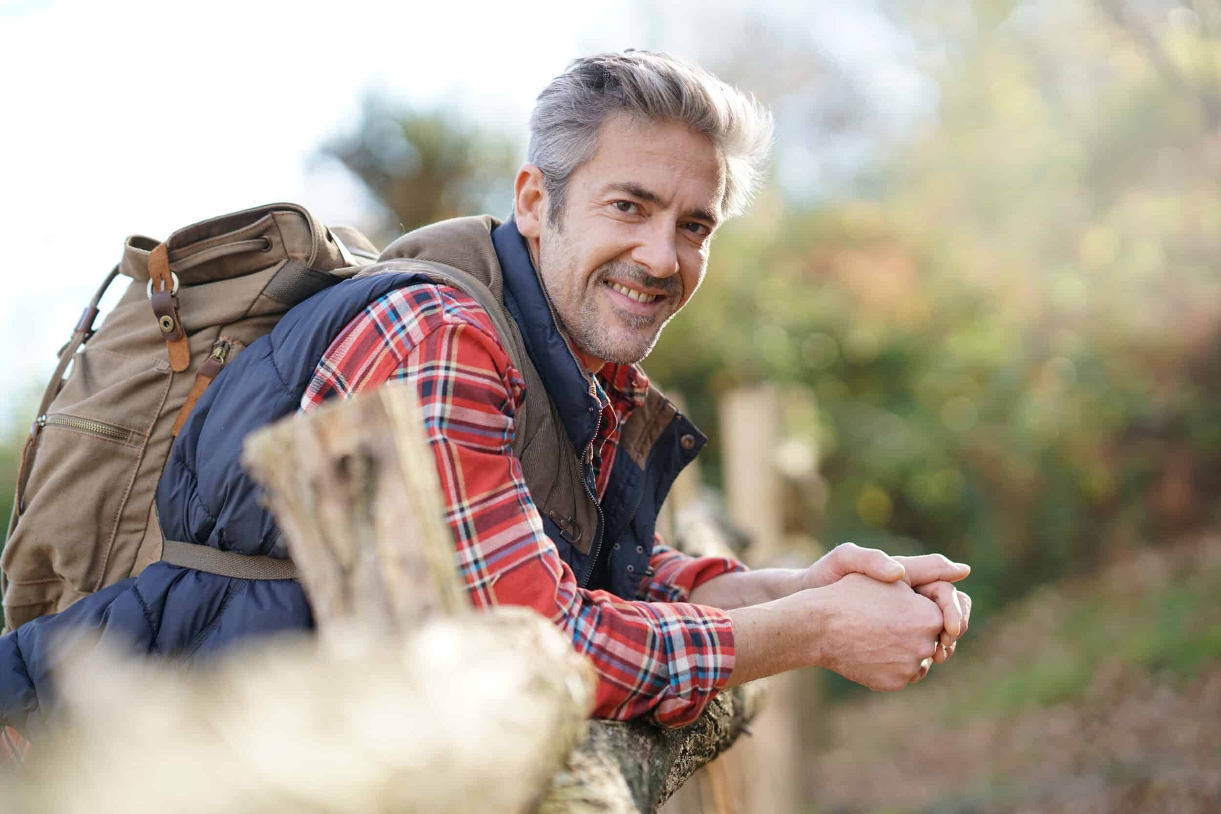 Man with large backpack is on a hike after HRT restored his energy levels